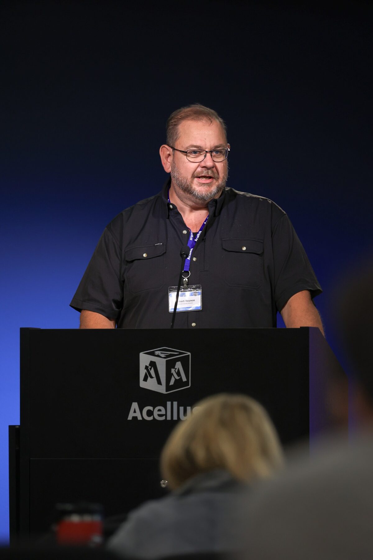 An administrator presenting from the Acellus lectern during a conference session