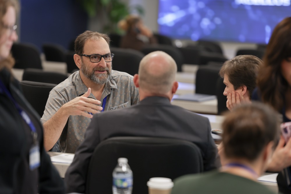 Administrators in discussion at a table during a session