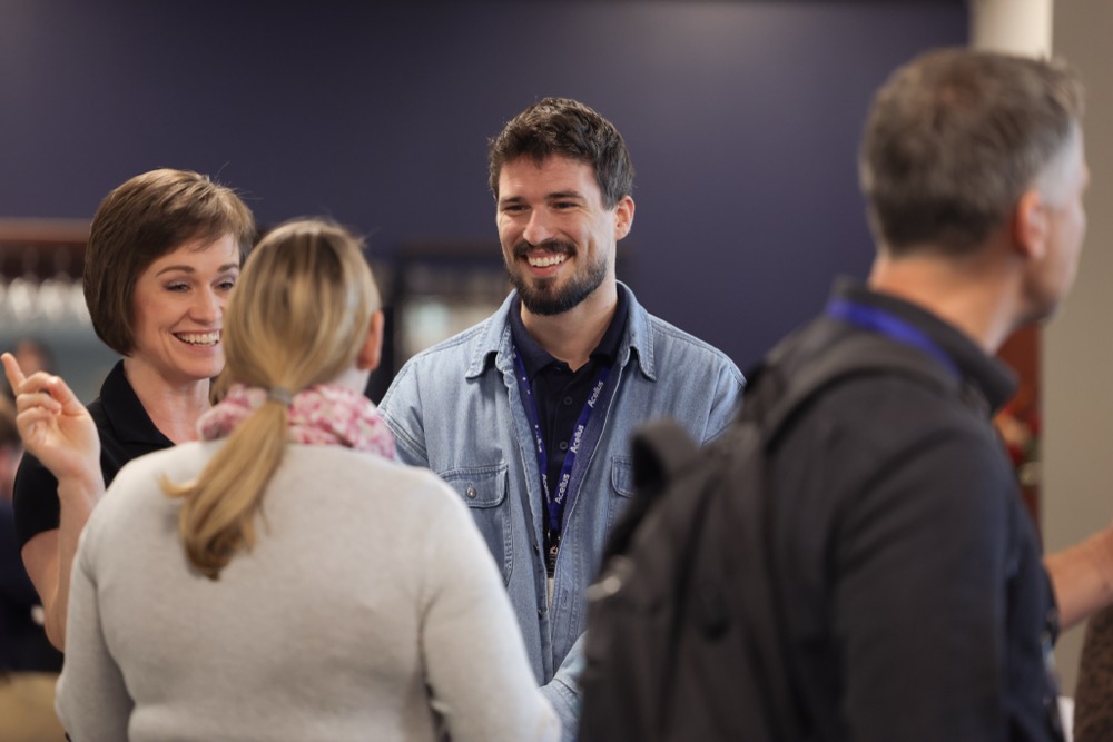 Attendees talking in the hallway between sessions